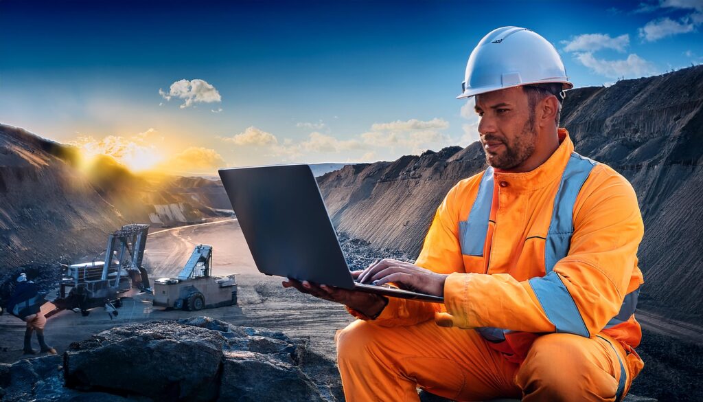 miner in high vis using a laptop